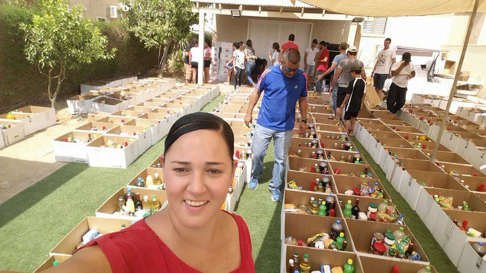 המנות מוכנות ומזומנות: ציפורה חלפון וברקע, מאות המנות שיחולקו עוד מעט (צילום: פייסבוק אישי)